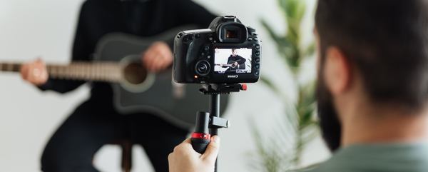 Un homme qui film un musicien