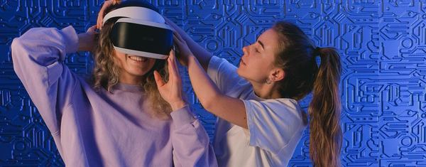 Une fille met le casque VR de son amie