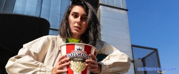 une femme porte une boîte de pop-corn