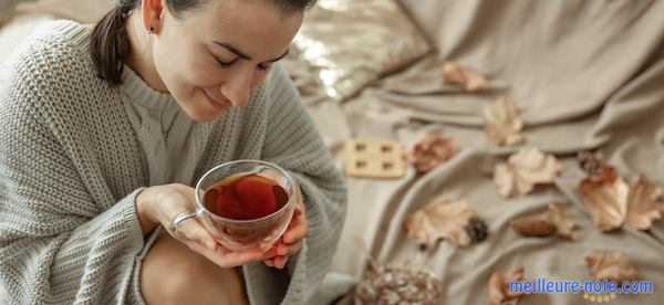 une femme prend une tasse du thé