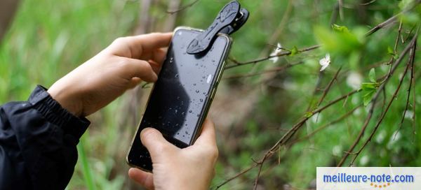 quelqu'un apporte son smartphone avec sa lentille 