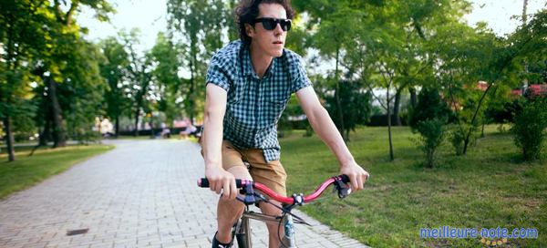 un homme avec lunette et son vélo