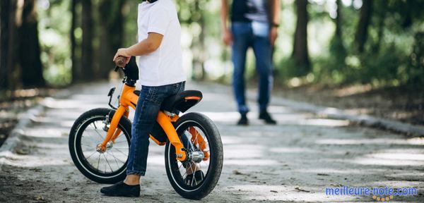 un petit avec son vélo jaune