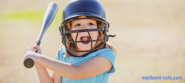 une petite fille joue au baseball