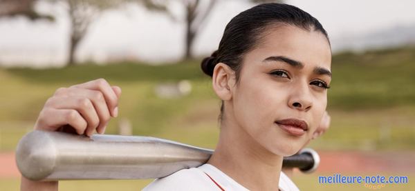 une femme tient une batte de baseball