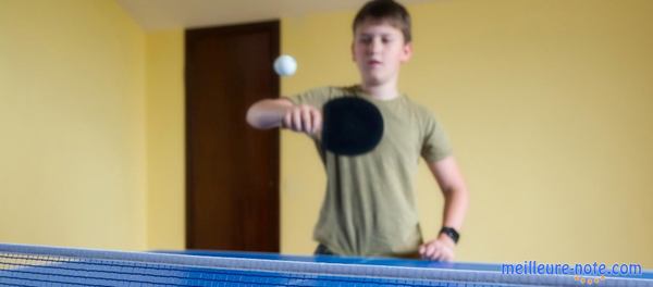 un petit garçon joue au ping pong