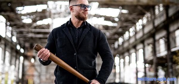 un homme tient une batte de baseball