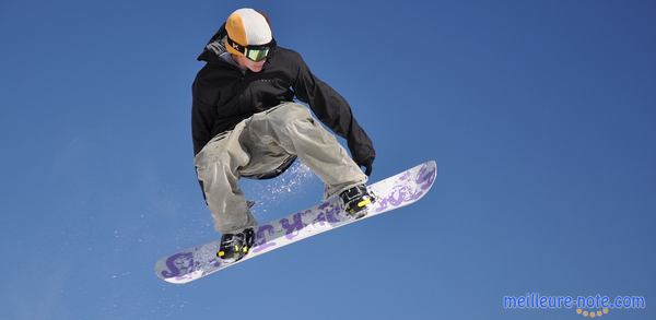 un jeune homme qui vole sur son snowboard