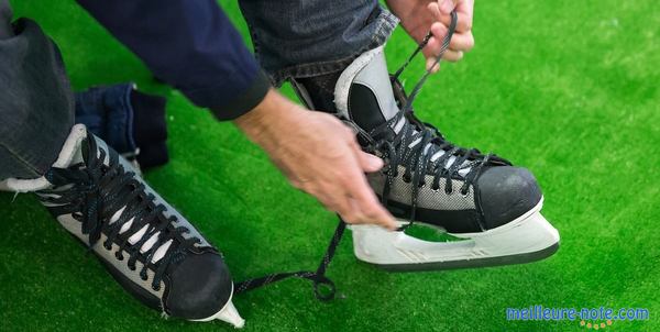 Des mains qui lassent des patins à glace