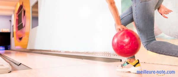 Une fille qui est en position du lancement de la boule