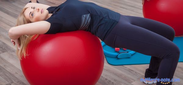 une femme dort sur un ballon rouge