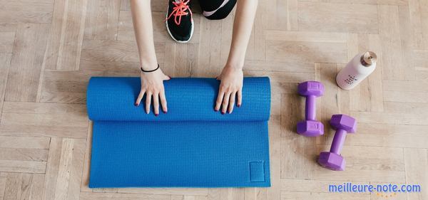 Une femme qui roule son tapis de gym