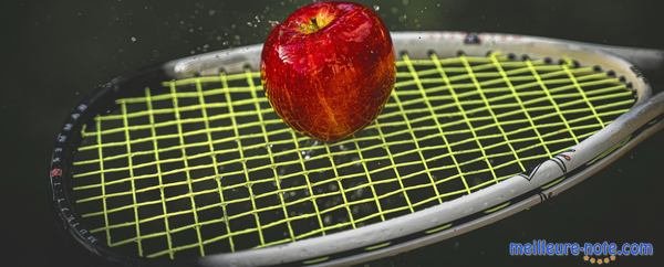 Une pomme sur une raquette de squash