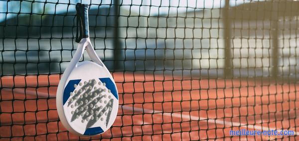 Une raquette de padel suspendue aux filets