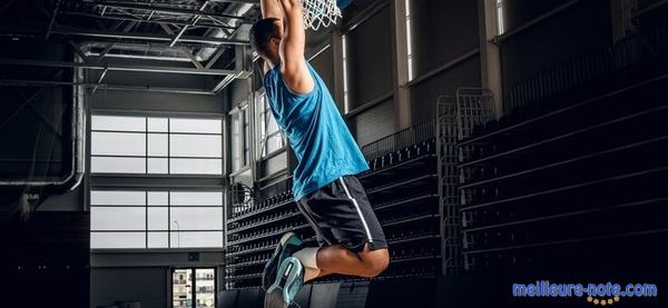 Un joueur de basket qui s'accroche au panier