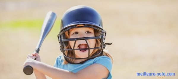 une petite fille joue au baseball