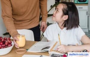 une petite fille qui fait des exercices dans son cahier