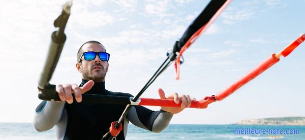 un homme tient la barre de kitesurf