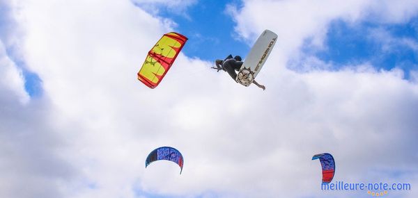 Une personne avec une planche de kitesurf et des ailes de kitesurf