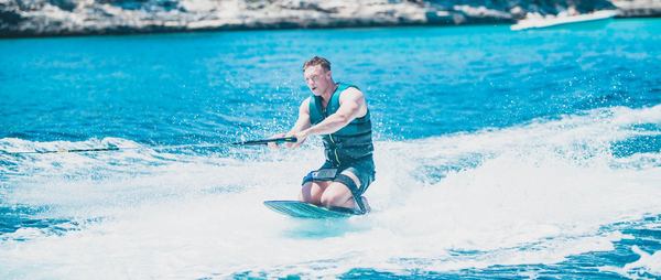 un homme glisse avec un kneeboard bleu