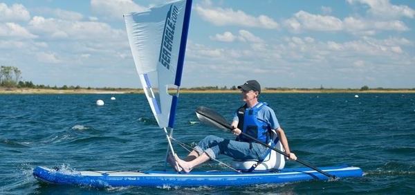 un monsieur et son kayak à voile