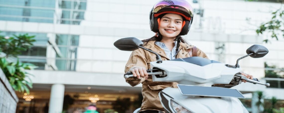 une femme sourit sur sa moto