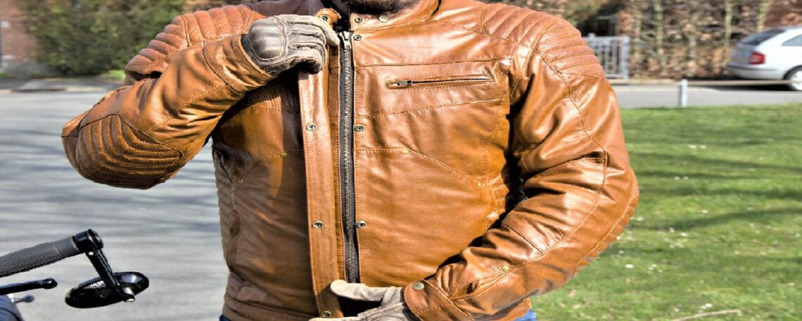 un homme met son blouson marron