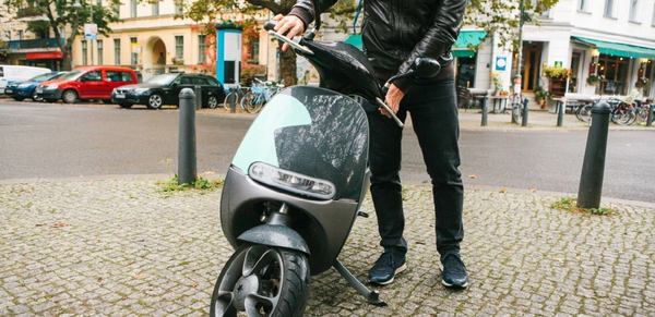 un homme et son scooter dans la rue