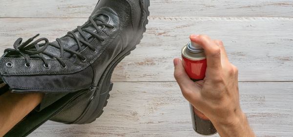 un homme nourrie sa chaussure avec un spray