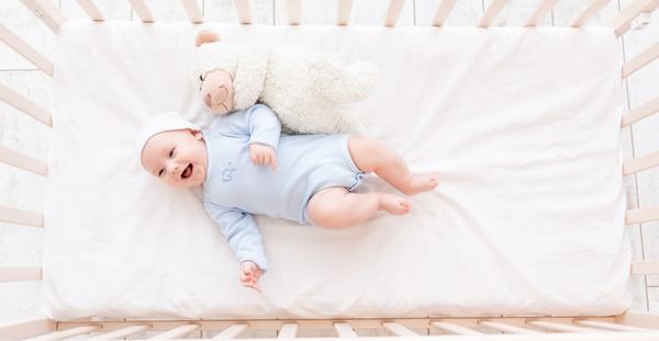 un bébé qui sourit sur le lit