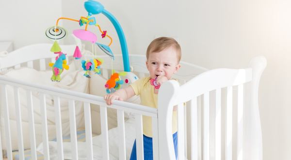 un petit garçon se lève sur son lit