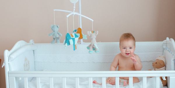 un bebe au dessus d'un mobile de lit