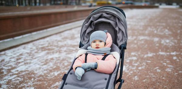 un petit bébé dans une poussette avec chancelière