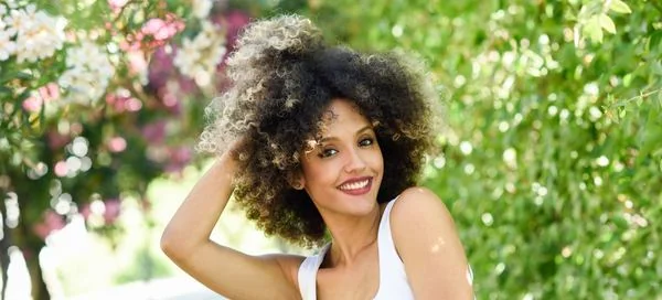 une belle métisse avec des cheveux frisés teintés