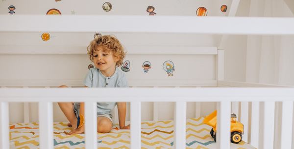 Un mignon petit garçon s'amuse dans son lit