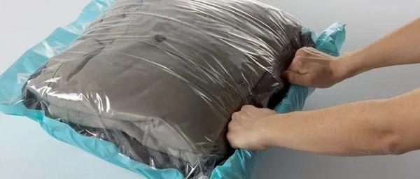 Une personne utilise un sac sous-vide pour économiser de la place